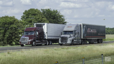 An ATS tractor-trailer passing an unidentified tractor-trailer on the highway.