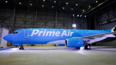 A bright blue plane with Prime Air logo sitting in a hangar.