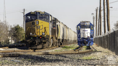 A CSX train hauling rail cars enters a rail yard.