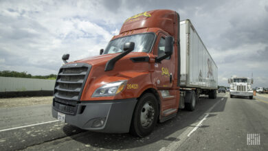 A red Saia tractor pulling a white Saia trailer on the highway