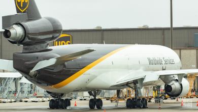 A brown-tailed UPS cargo jet at an airport, viewed from the rear.