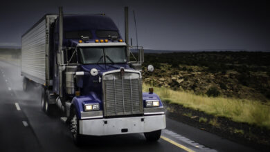 A truck rolls down the highway on a rainy day