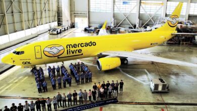 A bright yellow jet with Mercado Libre branding inside a hangar.