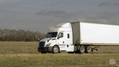 A white tractor-trailer on highway