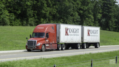 A red Knight tractor pulling two Knight LTL trailers