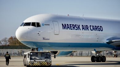 A side view of the front half of a white Maersk Air Cargo jet on the ground.