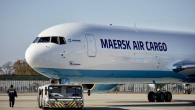 A side view of the front half of a white Maersk Air Cargo jet on the ground.