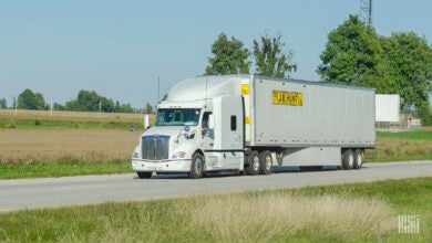 A white tractor pulling a J.B. Hunt trailer