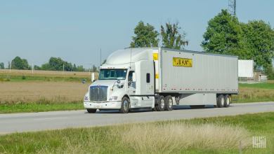 A white tractor pulling a J.B. Hunt trailer