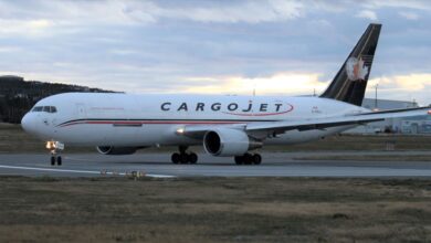 A blue-tailed Cargojet plane prepares for takeoff on an overcast day.