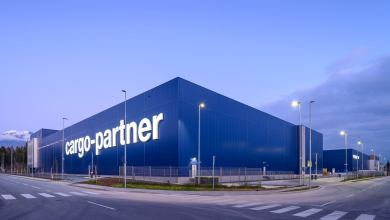 A blue warehouse with cargo-partner written on the side, against a blue sky
