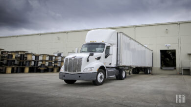 A white tractor-trailer backed into a warehouse door