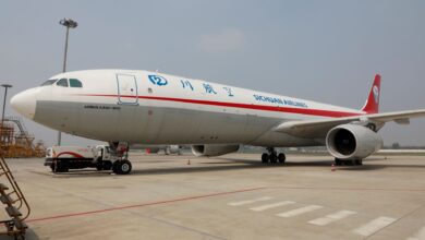 A cargo jet with red tail and Sichuan Airlines painted on the side is parked on the tarmac.