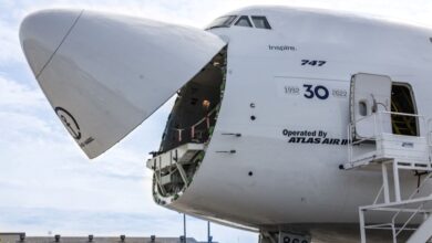 Close up of a white 747 cargo jet with the nose cone flipped up.