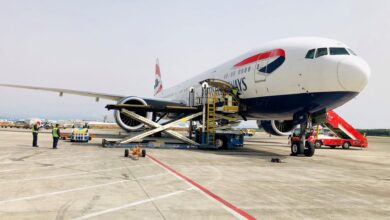 A British Airways jet with loading equipment against the cargo door.