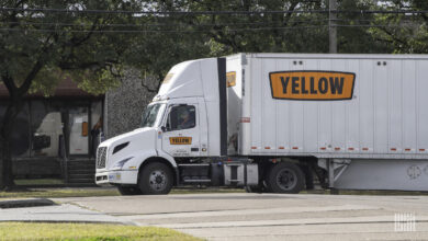 A Yellow truck entering a freight terminal