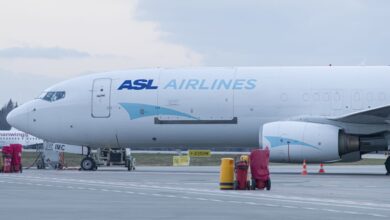 A white cargo jet with light blue ASL Airlines lettering at an airport.