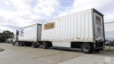 A Yellow tractor pulling two LTL trailers