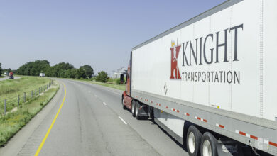 A red Knight Transportation tractor pulling a white Knight trailer