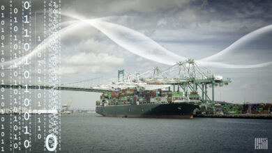 A large container shipped docked in a large bay with a bridge in the background.