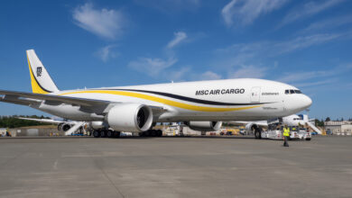 A white cargo jet with yellow trim and MSC Air Cargo label on the ground under a clear, blue sky.
