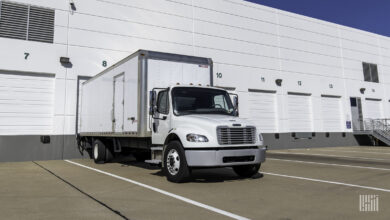 a white straight truck docked at a warehouse