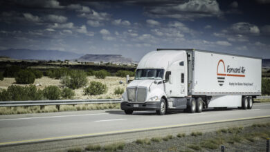 A white tractor pulling a Forward Air trailer on the highway