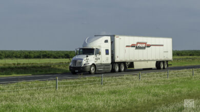 A white Pam tractor pulling a white Pam trailer