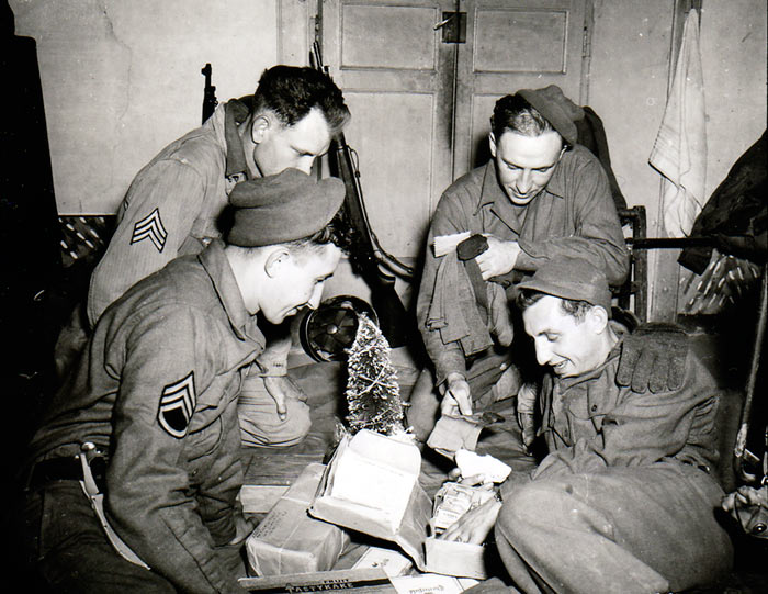 Soldiers opening Christmas items shipment by tree 