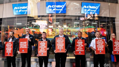 Pilots with red signs picketing outside the Nasdaq stock exchange.