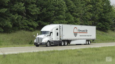 a white sleeper cab pulling a white Forward Air dry van trailer