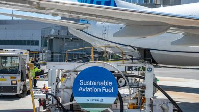 A jet being filled with sustainable aviation fuel at an airport. The fuel dolly has a blue SAF sign on it.
