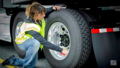 Truck driver inspecting tires.