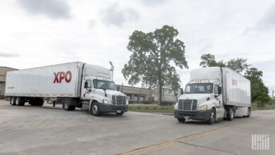 XPO trucks in motion in front of terminal