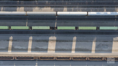 A rail yard with parked intermodal containers and railcars.