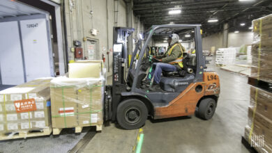 A truck being loaded by a forklift at a warehouse