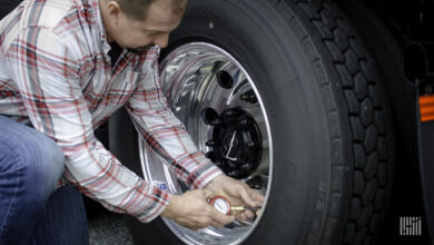 Truck driver checking tires.