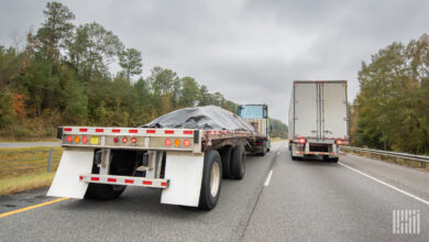 A tarp-covered load on a flatbed rig