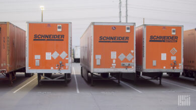Multiple parked orange Schneider trucks