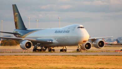 A brown-tailed UPS jumbo jet rolls on an airport roadway.