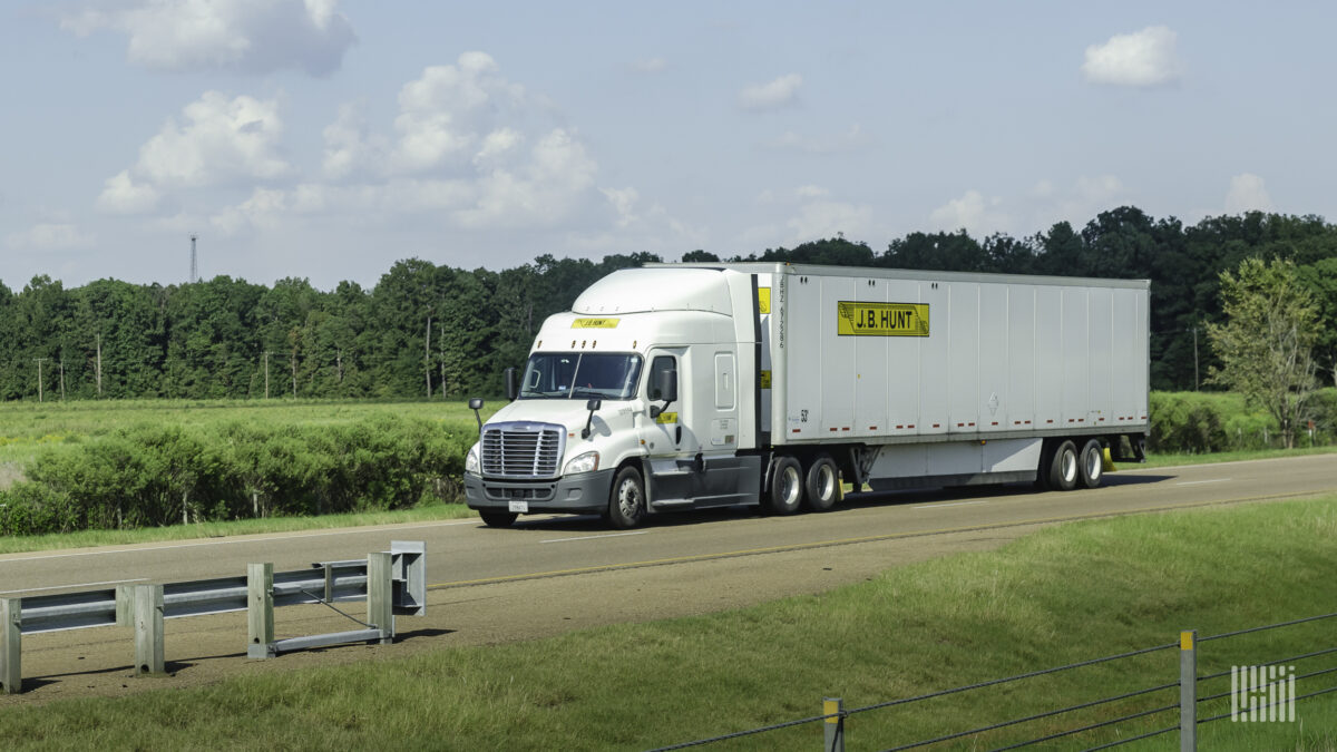 A white J.B. Hunt sleeper tractor pulling a white J.B. Hunt dry van trailer