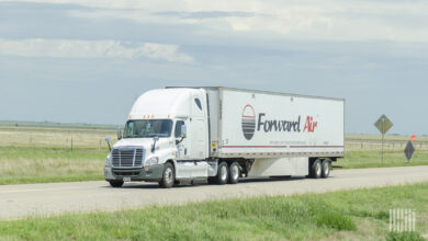 A white tractor pulling a white Forward Air trailer on a highway