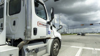 A white Trimac daycab at a stoplight