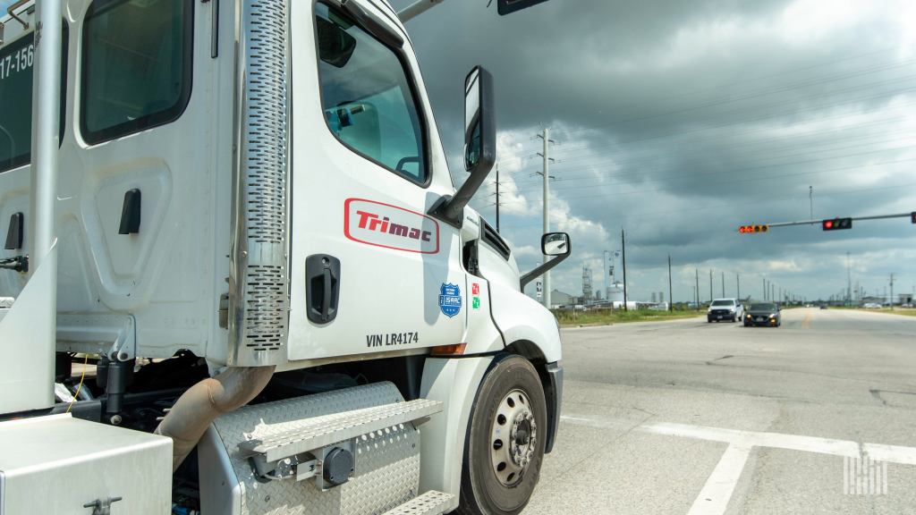 A white Trimac daycab at a stoplight