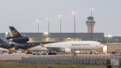 A brown-tailed UPS jet parked at an airport on a cloudy day.