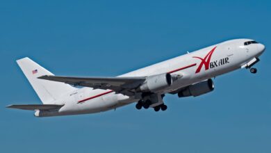 A white ABX Air freighter takes off as seen in air with wheels down.