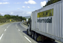 A tractor pulling a J.B. Hunt intermodal container on a highway