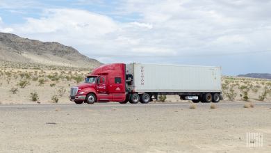 A maroon Knight Transportation tractor pulling a refrigerated Triton container