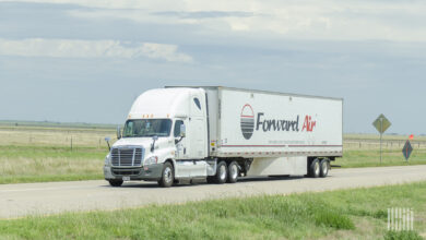 A white tractor pulling a white Forward Air trailer