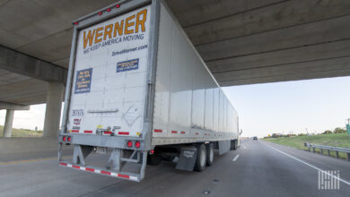 A Werner tractor-trailer under an overpass on a highway